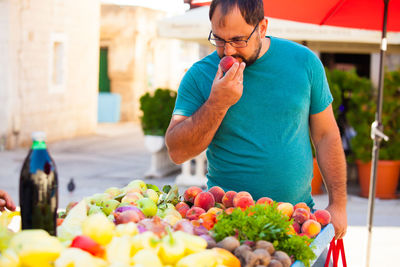 Midsection of man holding fruits in market