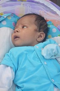 Portrait of cute baby lying on bed