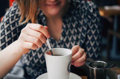 Close-up of woman drinking coffee cup in cafe