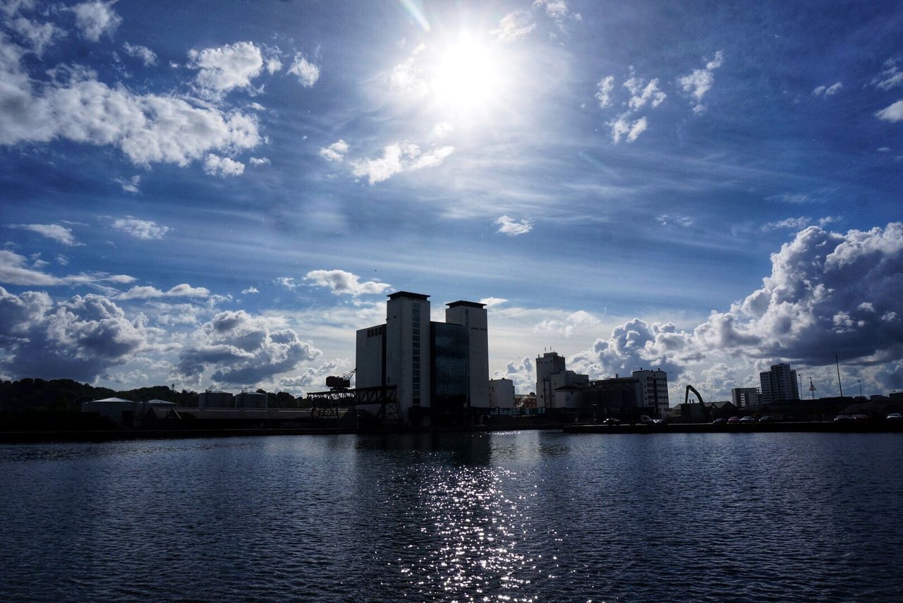 SEA BY BUILDINGS AGAINST SKY