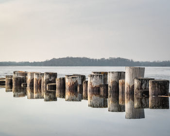 Panoramic view of wooden posts in lake against clear sky