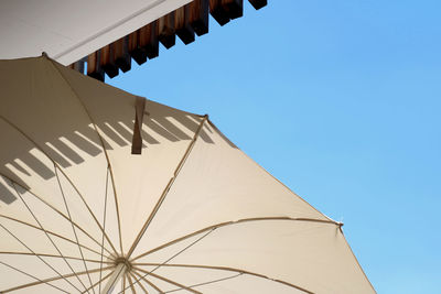 Low angle view of parasol against blue sky