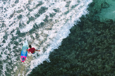 High angle view of man with surfboard in sea