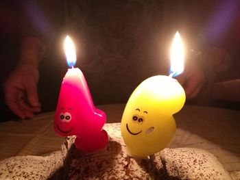 Close-up of burning candles on sand