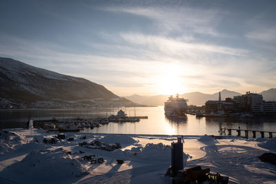 Tromsø port with cruise yacht and sunset behind mountain during winter. panoramic view.