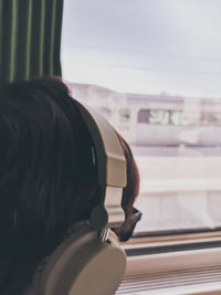 Rear view portrait of woman seen through window