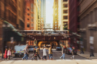 People walking on road along buildings