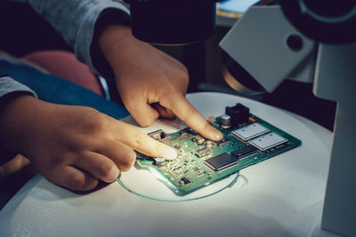 Midsection of man using mobile phone on table