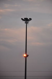 Low angle view of illuminated street light against sky at sunset