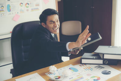 Man using laptop while sitting on table