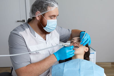 Dentist examining patient at clinic