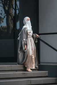 Rear view of woman standing against wall