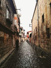 Alley amidst buildings against clear sky