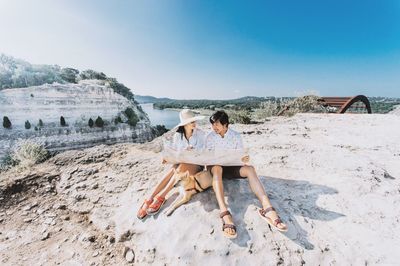 People sitting on land against sky