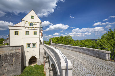 Low angle view of arch bridge by buildings against sky