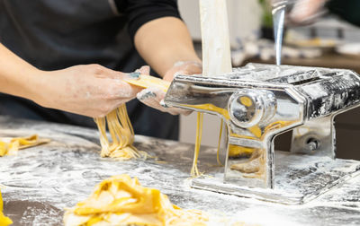 The process of making homemade pasta using a pasta machine.