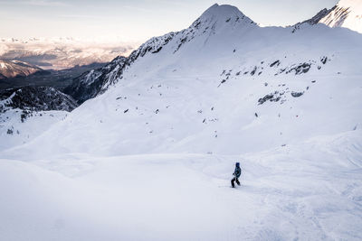 Person skiing on snowcapped mountain against sky