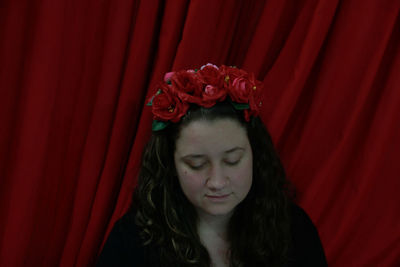 Portrait of a beautiful young woman with red eyes closed