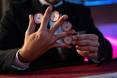 Midsection of man holding clock on table