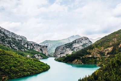 Scenic view of lake by mountains against sky