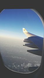 Cropped image of airplane flying over blue sky