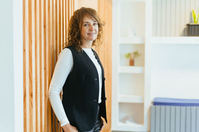 Portrait of young woman standing at home