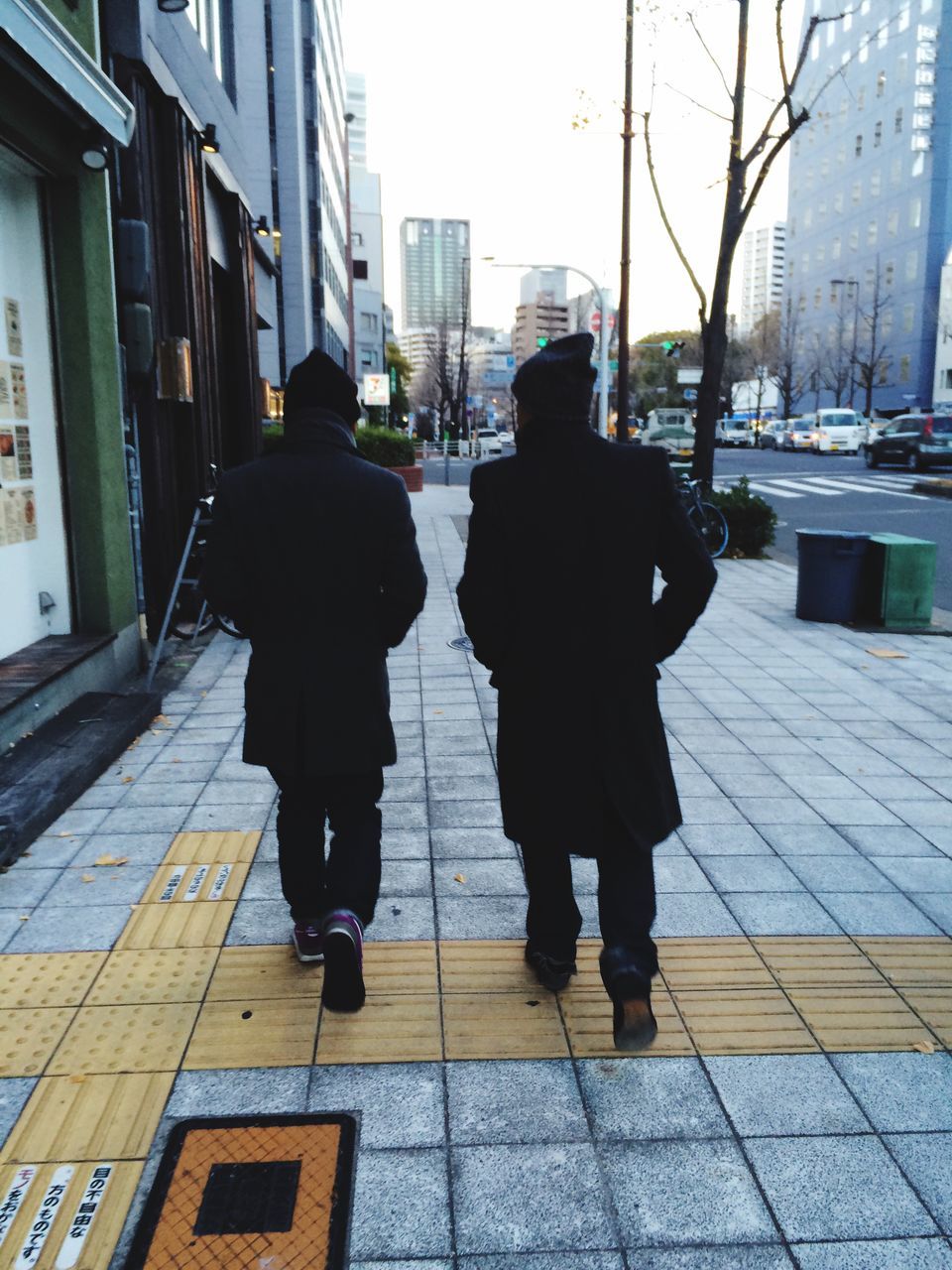 rear view, walking, full length, building exterior, architecture, built structure, city, men, lifestyles, the way forward, city life, person, sidewalk, street, footpath, day, standing