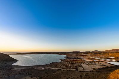 Scenic view lanzarote salt basins against clear sky during sunset