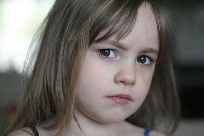Close-up portrait of cute sulking girl at home