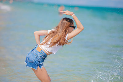 Rear view of woman standing in swimming pool