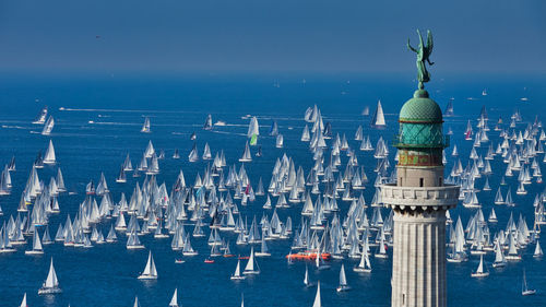 Aerial view of buildings in sea against blue sky