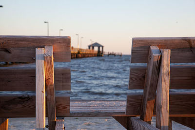 Wooden posts on beach against clear sky