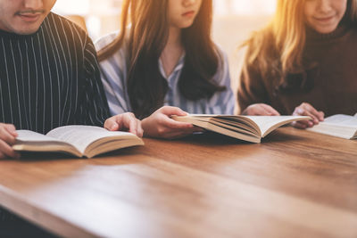 Midsection of woman reading book