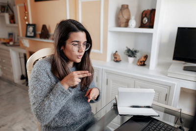 Young woman using mobile phone at home