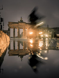 Brandenburg gate reflecting on puddle at night