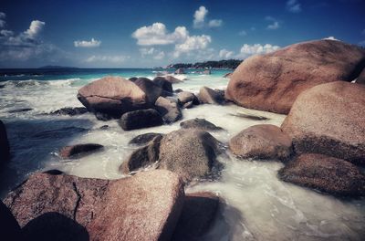 Rocks on beach against sky