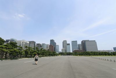 Rear view of man walking on road in city