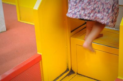 Low section of girl climbing on cabinet