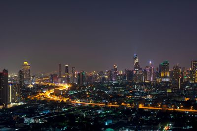 Illuminated cityscape against sky at night