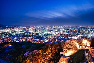 Illuminated cityscape against sky at night