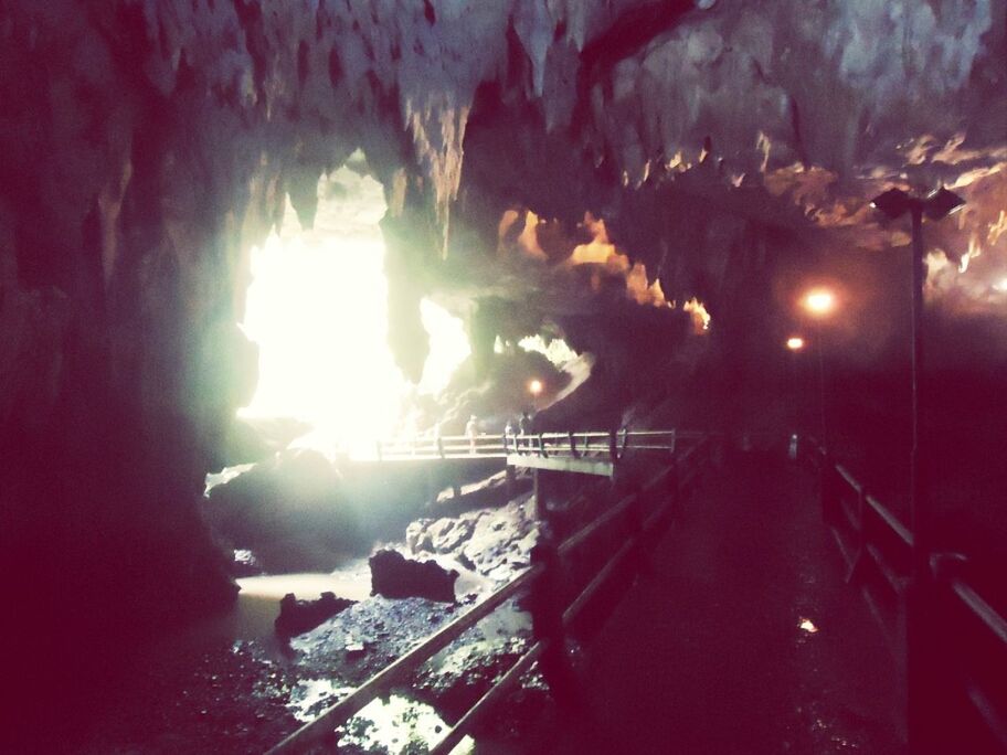 indoors, built structure, cave, illuminated, architecture, water, rock - object, mountain, night, sunbeam, sunlight, lens flare, men, rock formation, lighting equipment, incidental people, travel destinations, travel