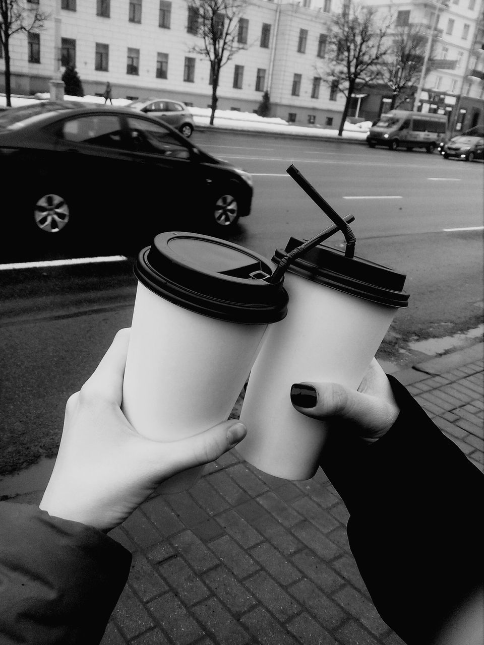 human hand, street, human body part, car, real people, building exterior, architecture, land vehicle, outdoors, built structure, human finger, city, day, personal perspective, mode of transport, sidewalk, road, transportation, one person, holding, disposable cup, men, lifestyles, close-up, people