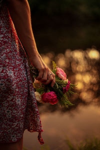 Midsection of woman holding flower bouquet