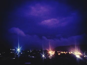 Panoramic shot of illuminated city against sky at night