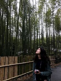 Full length of woman standing in forest