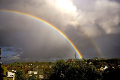 Scenic view of rainbow over buildings against sky