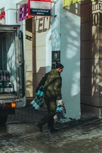 Rear view of man walking on street in city