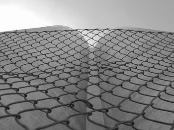 Low angle view of metal fence against sky