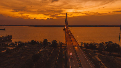 High angle view of road by sea against sky during sunset