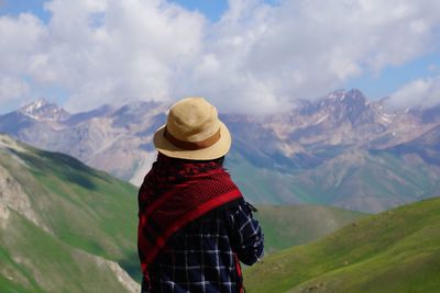 Rear view of woman standing against mountains